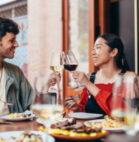 smiling interracial couple toasting with wine in a bar. Lifestyle